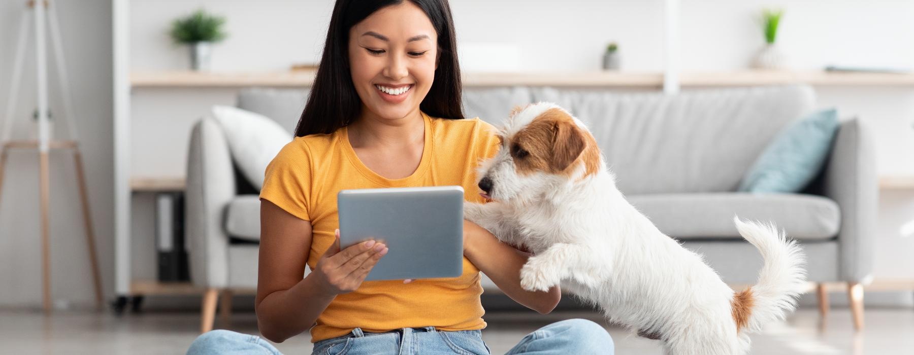 a woman sitting on the floor with a dog