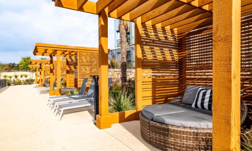 Settle into comfort at Reveal 54 a patio with a couch and a bench