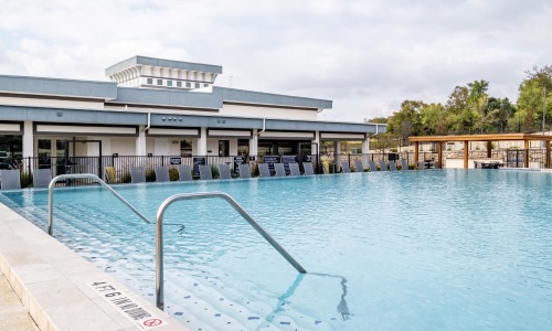 Relax and unwind poolside a pool with a building in the background