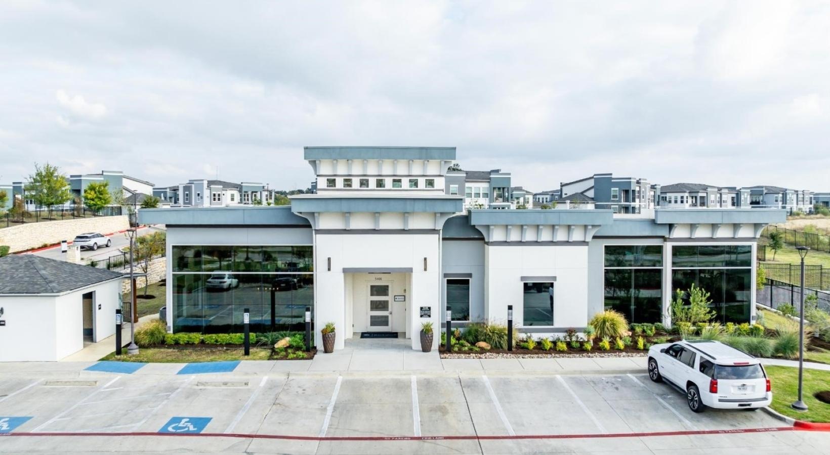 Find your perfect fit at Reveal 54 a white building with a parking lot